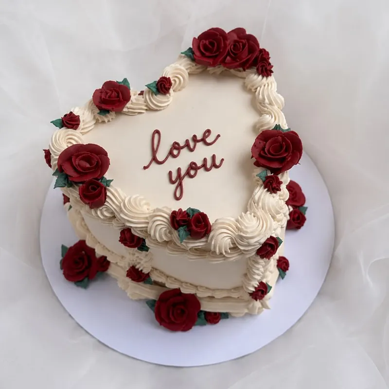 Kalp şeklinde kırmızı gül süslemeli Love You pastası